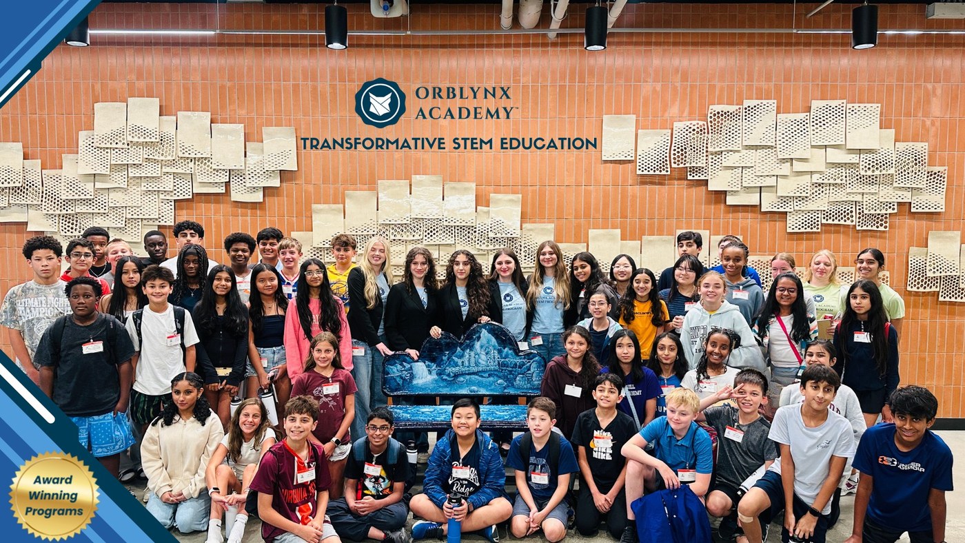 An Orblynx Academy student cohort gathered with the BioBench in front of the Orblynx Academy wall