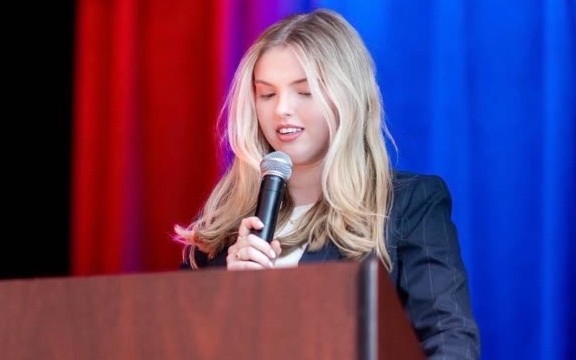 Olivia speaking at a podium