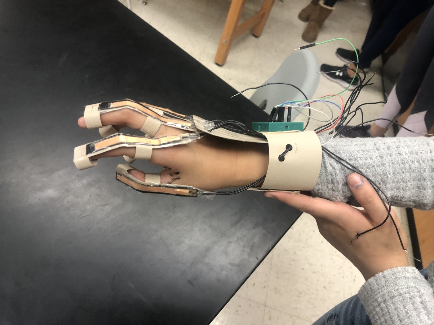 A student-built assistive hand device wired to a controller in an Orblynx lab