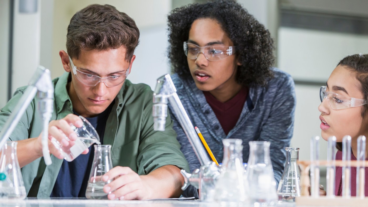 Orblynx students conducting a lab experiment with beakers and safety goggles