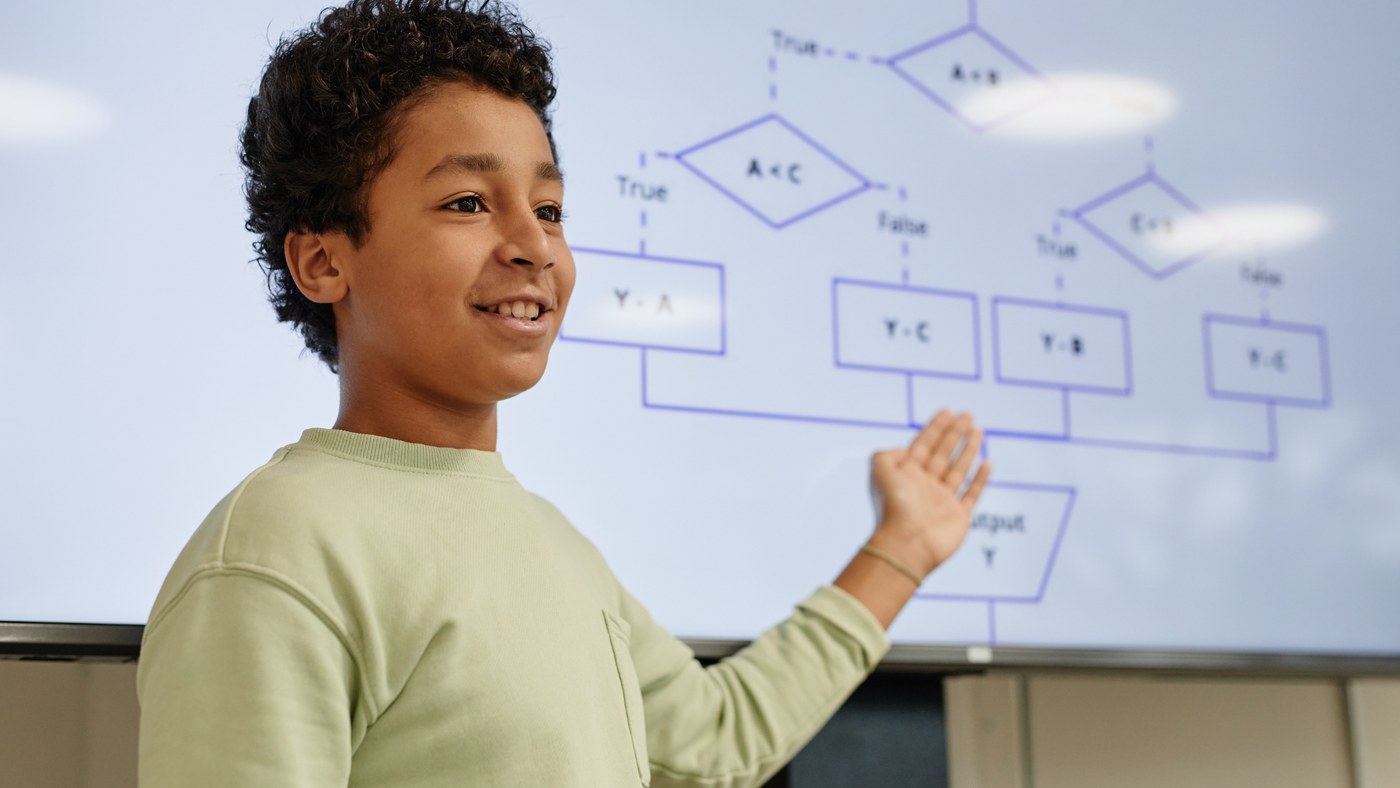 An Orblynx student presenting research findings at a showcase, explaining a flowchart on screen
